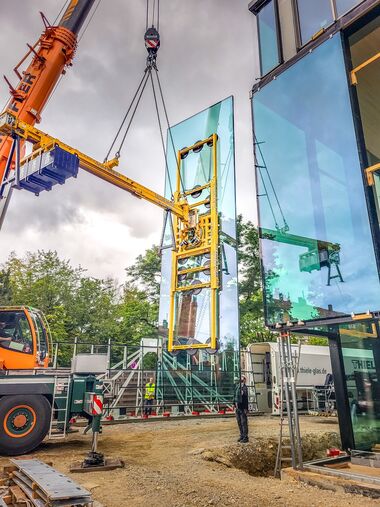 Einheben einer großformatigen Scheibe mit Vakuum-Sauganlage und Kontergewichten.