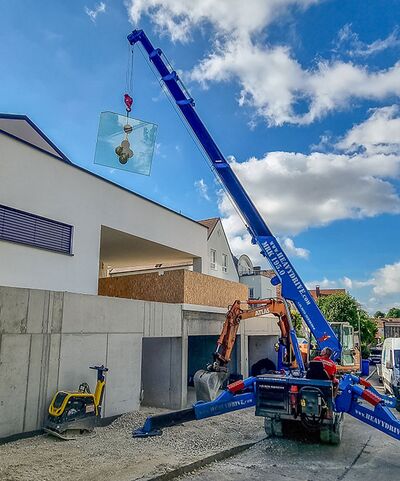 Montagekran hebt Scheibe zur Übergabe an Minikran zum Montageort