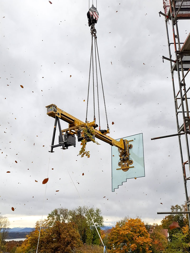 Treppenförmige Glasscheibe an der Vakuumsauganlage mit Kontergewicht bei starkem Wind.