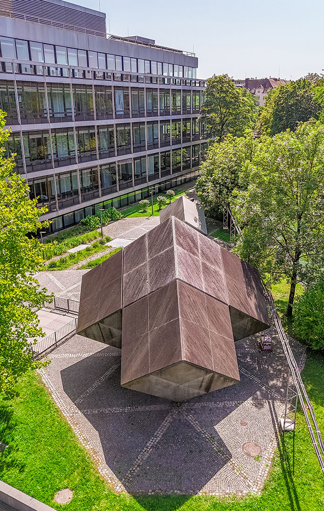 Im Hintergrund der fertiggestellter Gebäudekomplex am Tucherpark in München mit montierten Granit- und Glasfassadenelementen<br>Bildrechte: Heavydrive.com